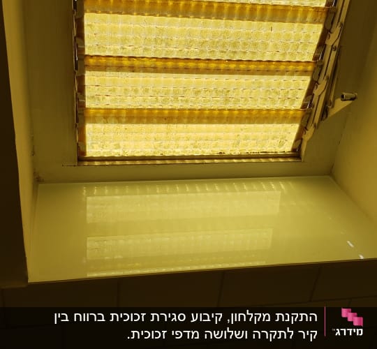 זכוכית מחזירה אור מתחת לחלון עם תריסים צהובים